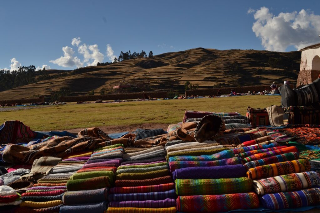 Textiles with local patterns laying down at the floor at the Chinchero Market.