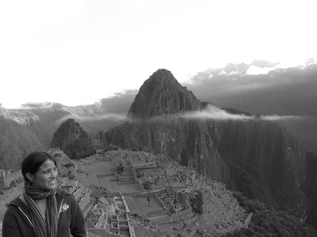 Me standing in front of the Machu Picchu ruins, in a black and white picture.