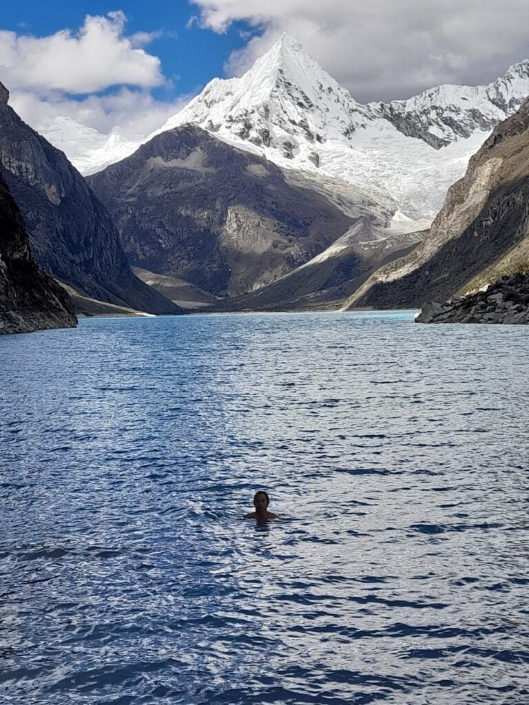 My partner swimming at laguna Paron. There's a big snow-capped mountain in the background.