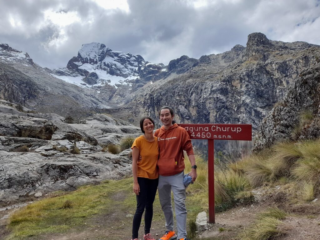 me and my partner in the mountains in Huaraz, a snow-capped peak on the background