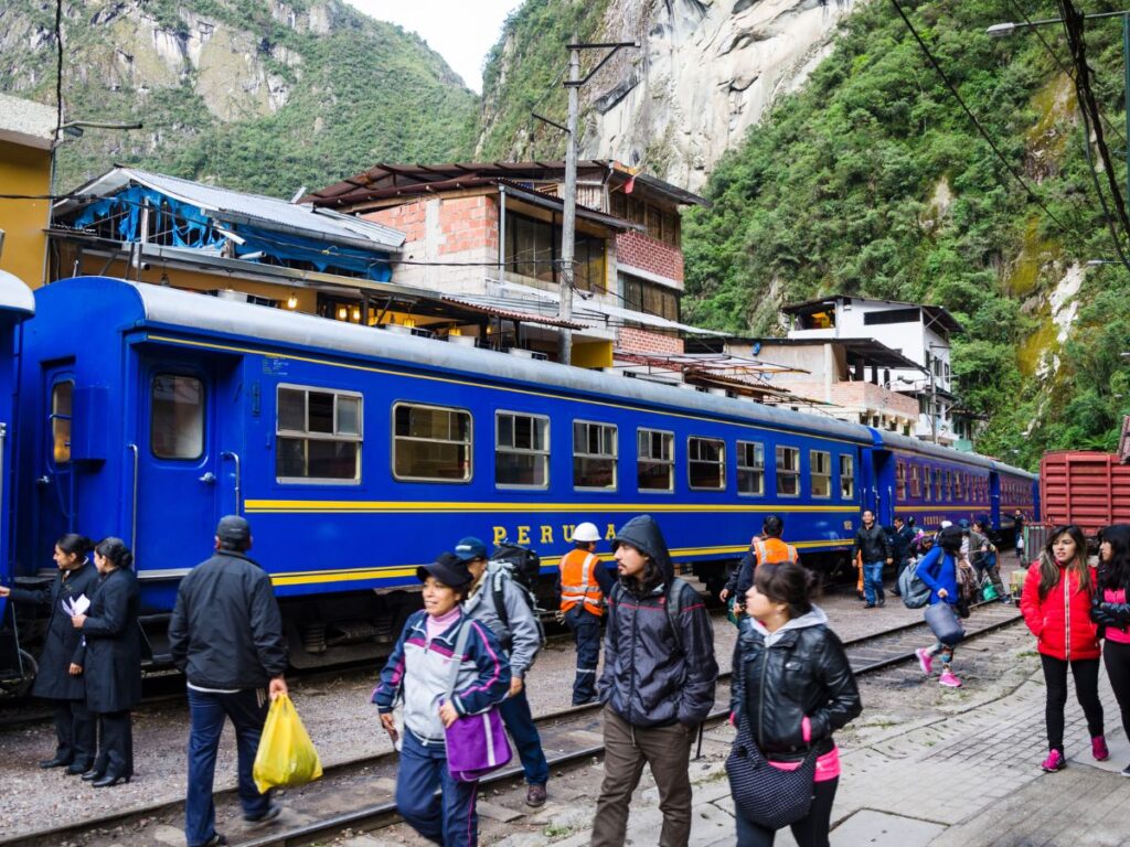 Passengers walking around the Machu Picchu train, getting around the Sacred Valley in Peru.
