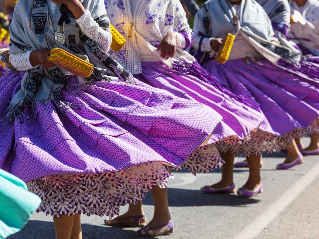 Women dancing wearing purple traditional skirts at the Virgen de la Candelaria festival in Puno