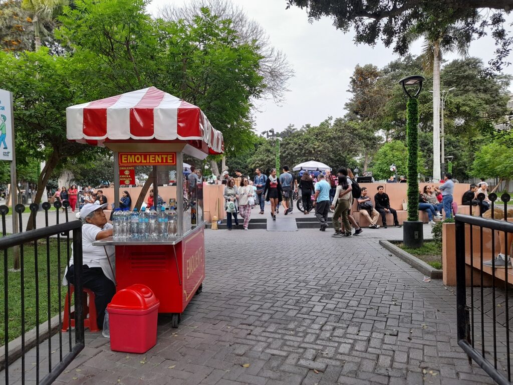 Street food vendor serving delicious local cuisine at Parque Kennedy against a grey sky, a typical sight in May for foodies visiting Lima.