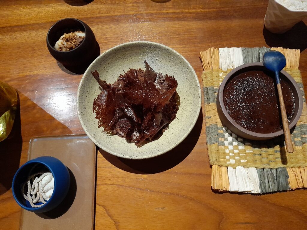 Fine dining dessert at Kjolle, in Lima, Peru: crunchy cacao textures served on a copazu bed, accompanied by dessert side dishes such as chocolate mousse and macambo.
