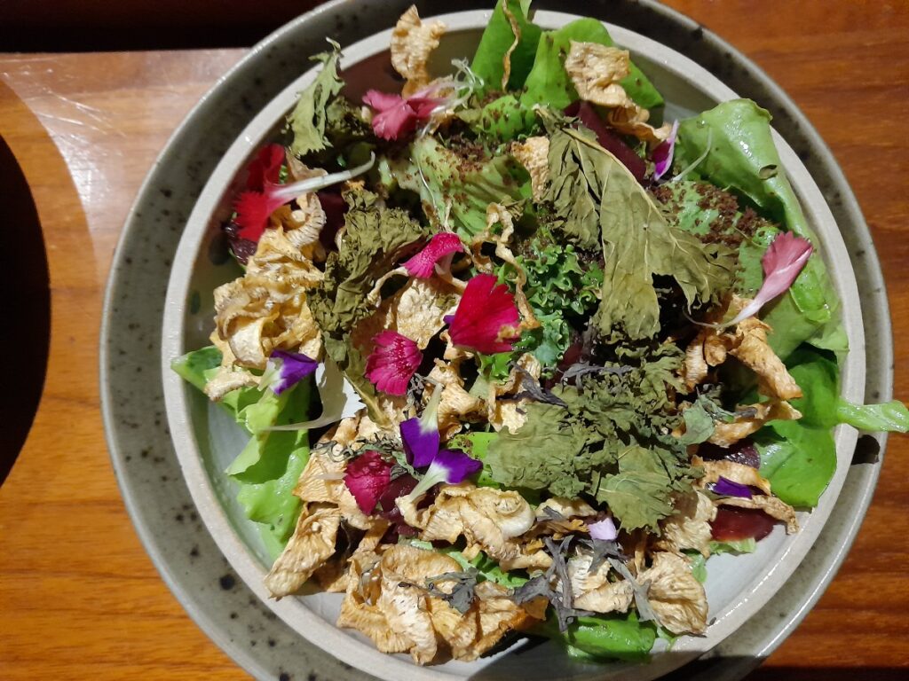 Vegetarian starter at Kjolle restaurant in Lima: kale, lettuce and dried artichoke topped by flowers.