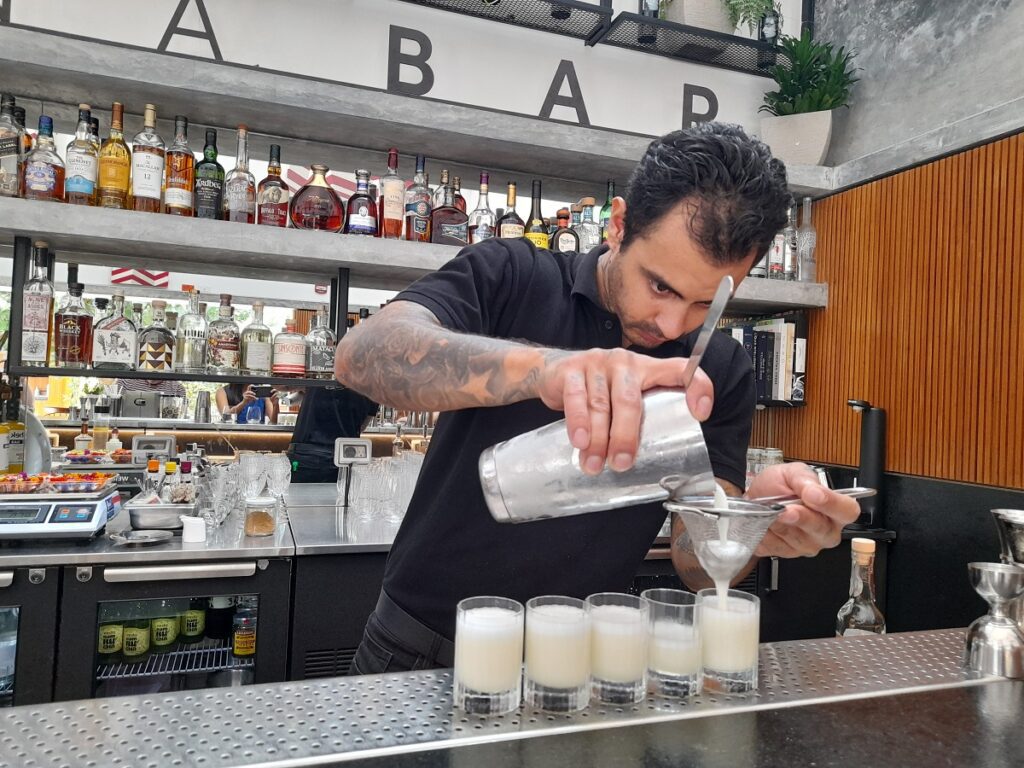 A barman at Limana restaurant in Lima, serving pisco sours, as part of our food tour.