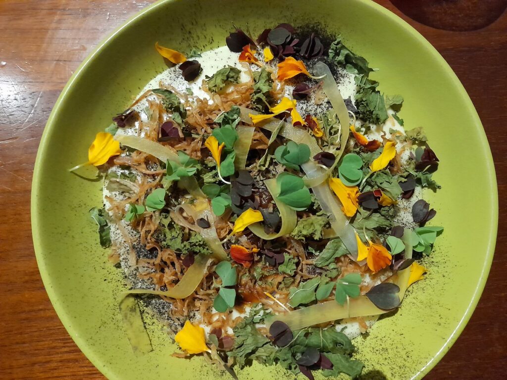 Vegetarian dish at restaurant Kjolle in Lima, Peru. A mix of several kinds of tubers: mashed potatoes, mashua, arracacha and carrots. Topped by flowers and leaves.